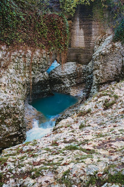 Tranquil view of a turquoise river flowing through a rocky canyon surrounded by natural beauty.